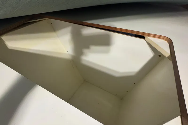 Slide: The Image of Storage compartment on a 2002 Leopard 42 boat, featuring wooden trim and white interior. - 75