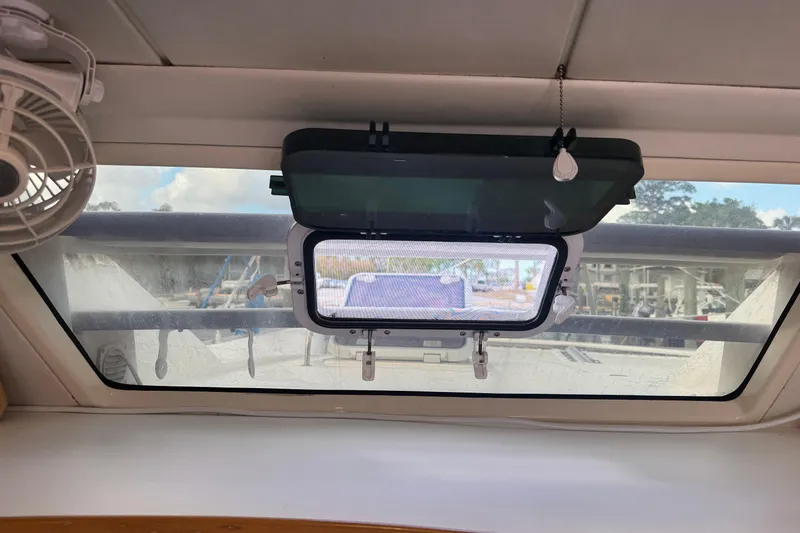 Slide: The Image of Interior view of a 2002 Leopard 42 yacht window with fan and open hatch. - 77