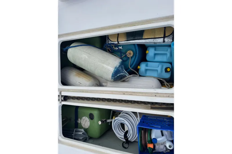 Slide: The Image of Storage compartment of a 2002 Leopard 42 boat with various equipment and supplies. - 78