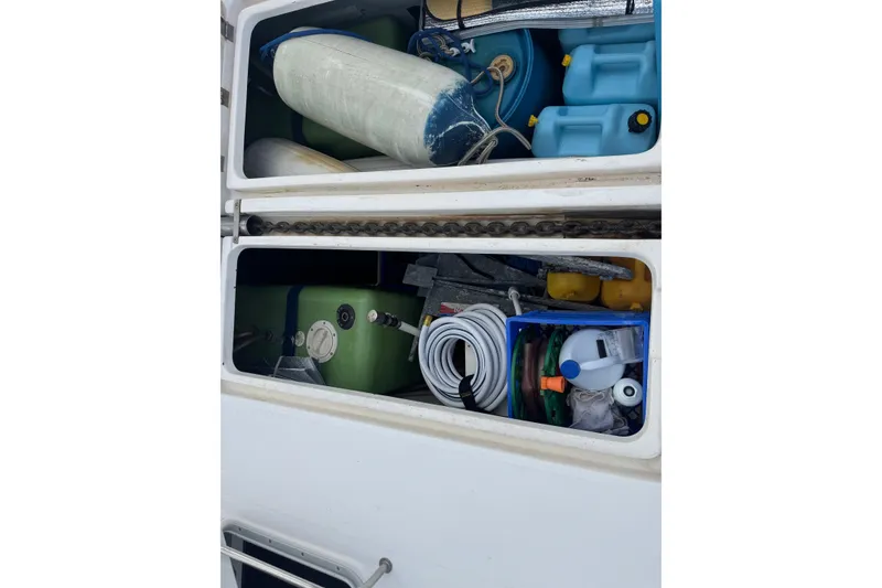 Slide: The Image of Storage compartments on a 2002 Leopard 42 boat, filled with various equipment and supplies. - 79