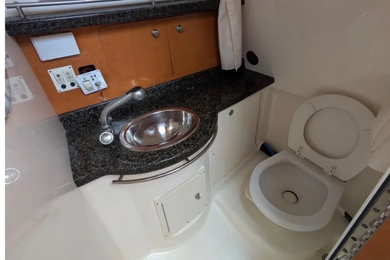 Slide: The Image of 2010 Robalo R305 Walkaround boat bathroom with sink and toilet. - 15