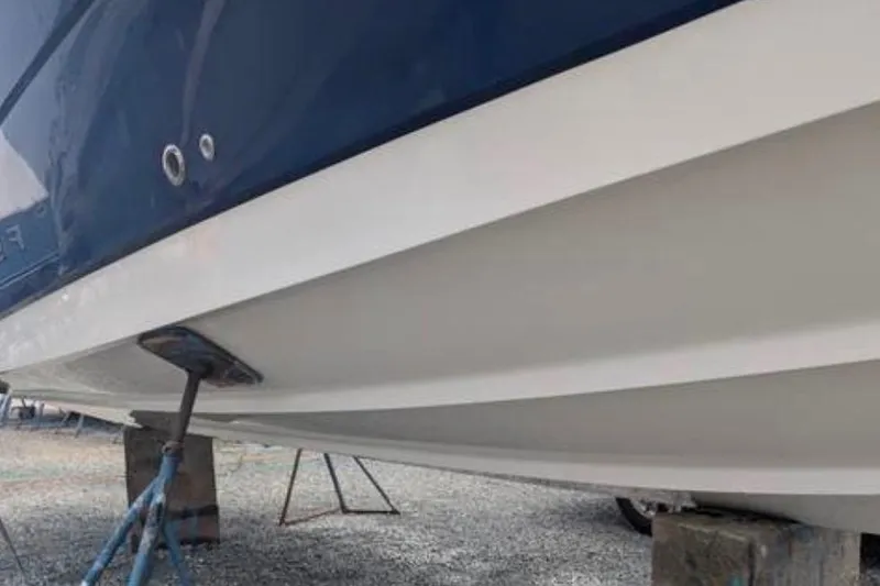 Slide: The Image of 2010 Robalo R305 Walkaround boat hull on stands, side view. - 2