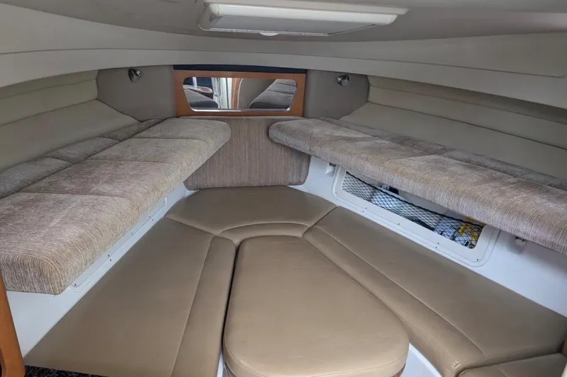 Slide: The Image of 2010 Robalo R305 Walkaround cabin interior with cushioned seating and storage. - 8
