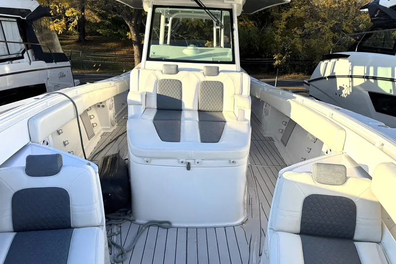 Slide: The Image of 2019 HCB 39 Speciale boat interior with white and gray seating, docked outdoors. - 10