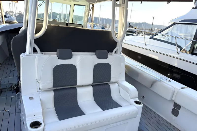 Slide: The Image of 2019 HCB 39 Speciale boat interior with white and gray seating at a marina. - 18
