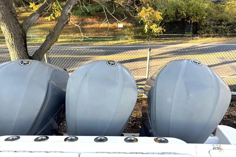 Slide: The Image of Three Yamaha outboard motors on a 2019 HCB 39 Speciale boat, near a fence and trees. - 38
