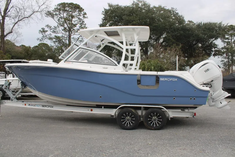 Slide: The Image of 2026 Sea Fox 268 Traveler boat on trailer, blue hull, dual engines, parked outdoors. - 4
