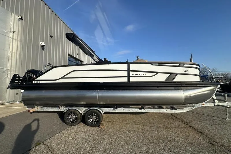 Slide: The Image of 2026 Evotti 523CS pontoon boat on trailer, parked outdoors under clear sky. - 5