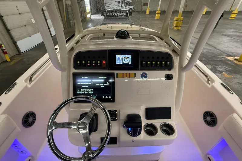 Slide: The Image of 2023 Grady-White Fisherman 216 boat dashboard with steering wheel and navigation controls. - 17