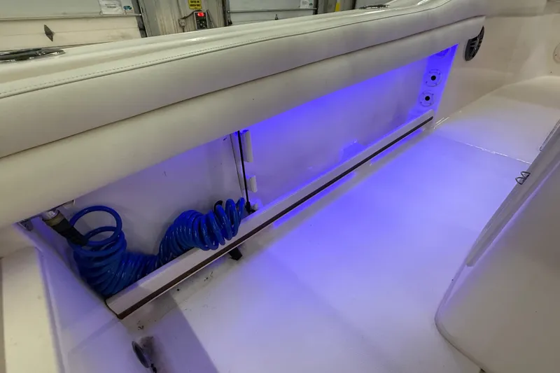 Slide: The Image of 2023 Grady-White Fisherman 216 boat interior with blue LED lighting and coiled hose. - 27