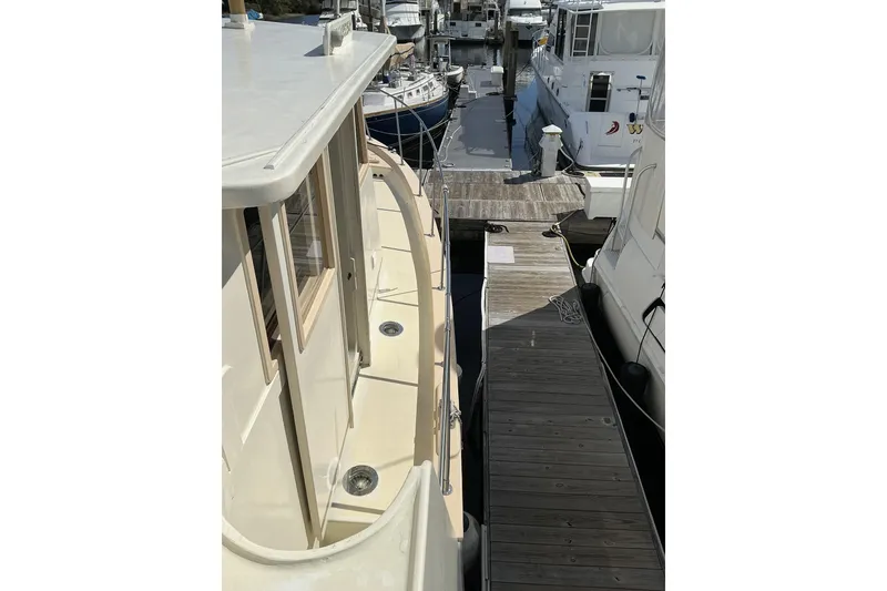 Slide: The Image of 2009 Hugh Huff Custom Pilothouse Trawler docked at marina, side view. - 12