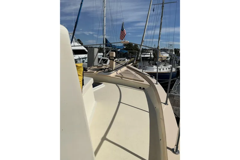 Slide: The Image of 2009 Hugh Huff Custom Pilothouse Trawler docked, showcasing deck and marina view. - 13