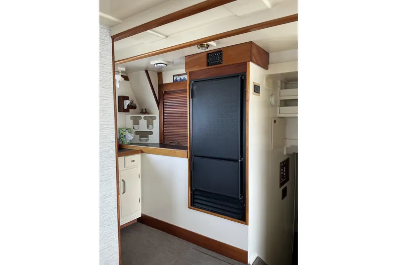 Slide: The Image of 2009 Hugh Huff Custom Pilothouse Trawler interior with wooden cabinetry and modern appliances. - 19