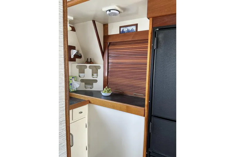 Slide: The Image of 2009 Hugh Huff Custom Pilothouse Trawler interior with wooden cabinetry and modern kitchen amenities. - 20