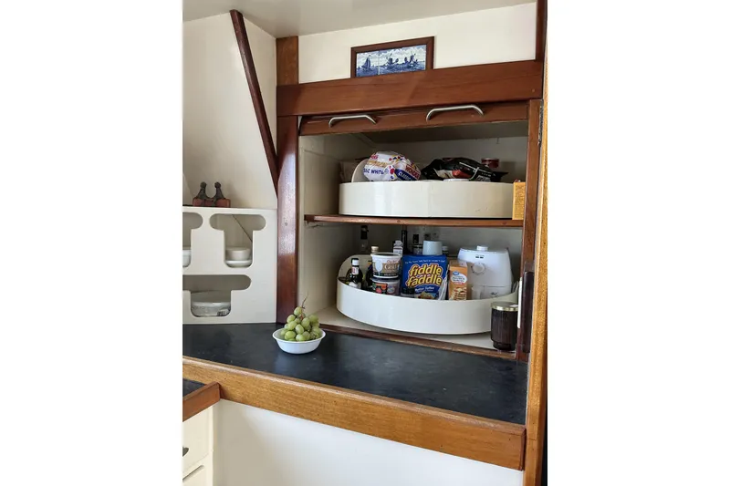 Slide: The Image of Interior of 2009 Hugh Huff Custom Pilothouse Trawler with organized kitchen storage and countertop. - 21