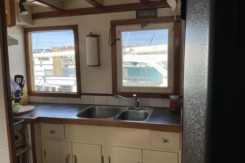 Slide: The Image of Interior of 2009 Hugh Huff Custom Pilothouse Trawler with kitchen sink and marina view. - 23