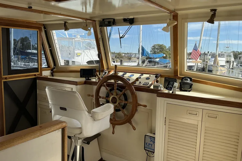 Slide: The Image of Pilothouse interior of 2009 Hugh Huff Custom Trawler with wooden wheel and navigation equipment. - 26