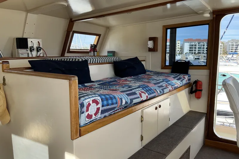 Slide: The Image of Interior of 2009 Hugh Huff Custom Pilothouse Trawler with nautical-themed seating and windows. - 31