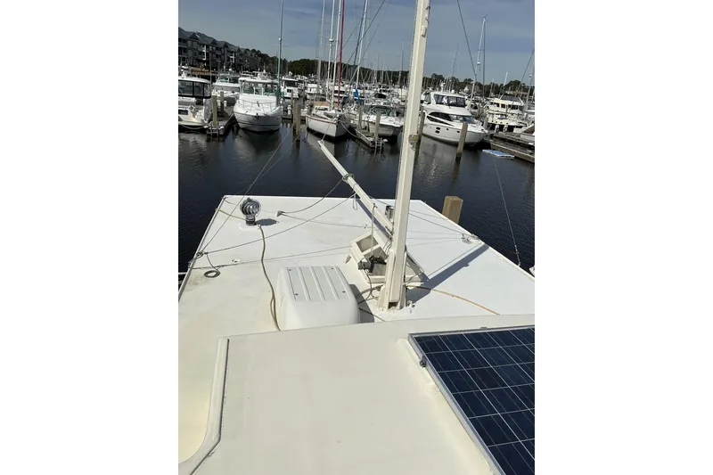 Slide: The Image of 2009 Hugh Huff Custom Pilothouse Trawler docked in a marina, featuring solar panels. - 9