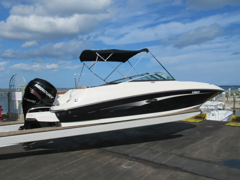 Slide: The Image of 2016 Sea Ray SunDeck 220 boat with black canopy on a sunny day. - 2