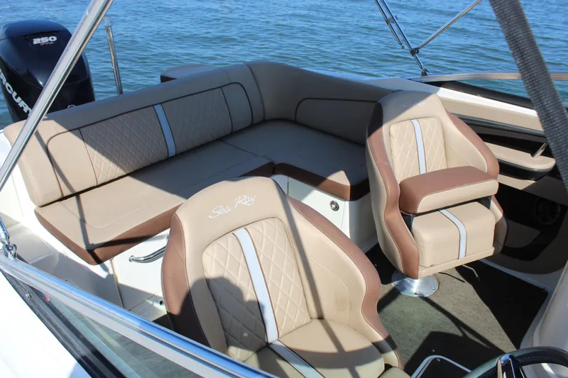 Slide: The Image of 2016 Sea Ray SunDeck 220 interior with beige seating and water backdrop. - 20
