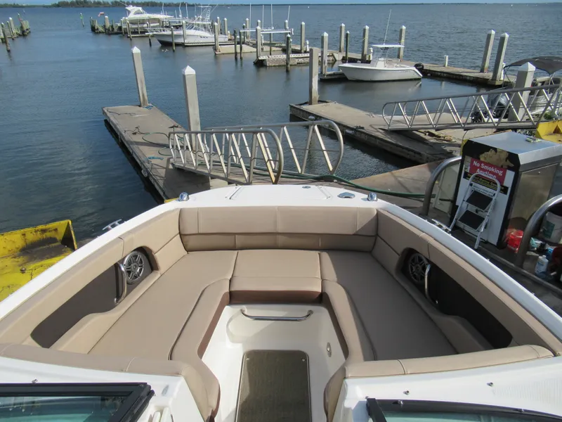 Slide: The Image of 2016 Sea Ray SunDeck 220 at marina, featuring spacious seating and scenic waterfront view. - 7