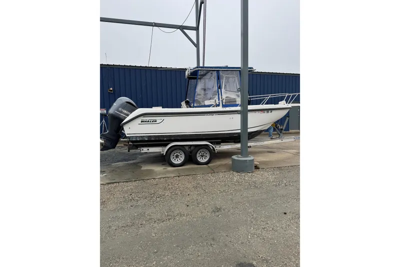 The Image of 1999 Boston Whaler 21 Outrage boat on trailer, parked outdoors. - 0
