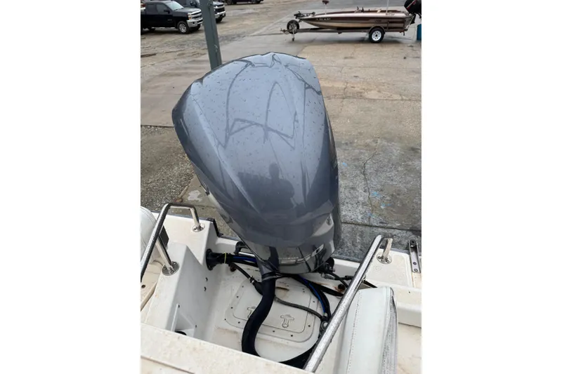 Slide: The Image of 1999 Boston Whaler 21 Outrage boat with a modern outboard motor in a parking area. - 11