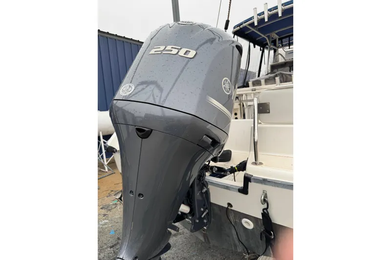 Slide: The Image of 1999 Boston Whaler 21 Outrage with Yamaha 250 outboard motor, docked in a marina. - 2