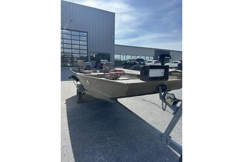 Slide: The Image of 2012 G3 1544 LW boat on trailer outside dealership, featuring camouflage seats. - 6