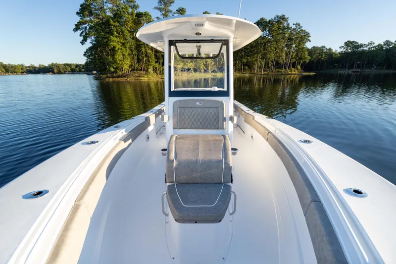 Slide: The Image of 2026 Sea Hunt Ultra 275 Coffin Box boat on serene lake with forest backdrop. - 33