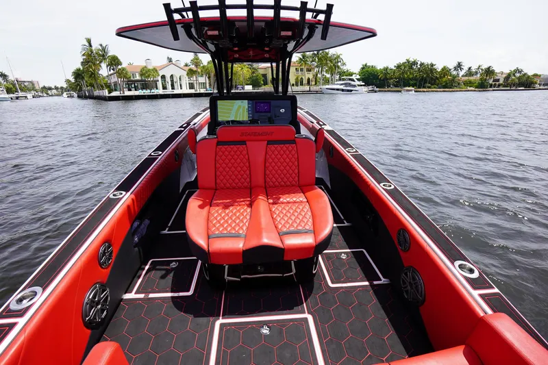 Slide: The Image of Luxurious 2020 Statement 380 Open boat with red seating on the water. - 7