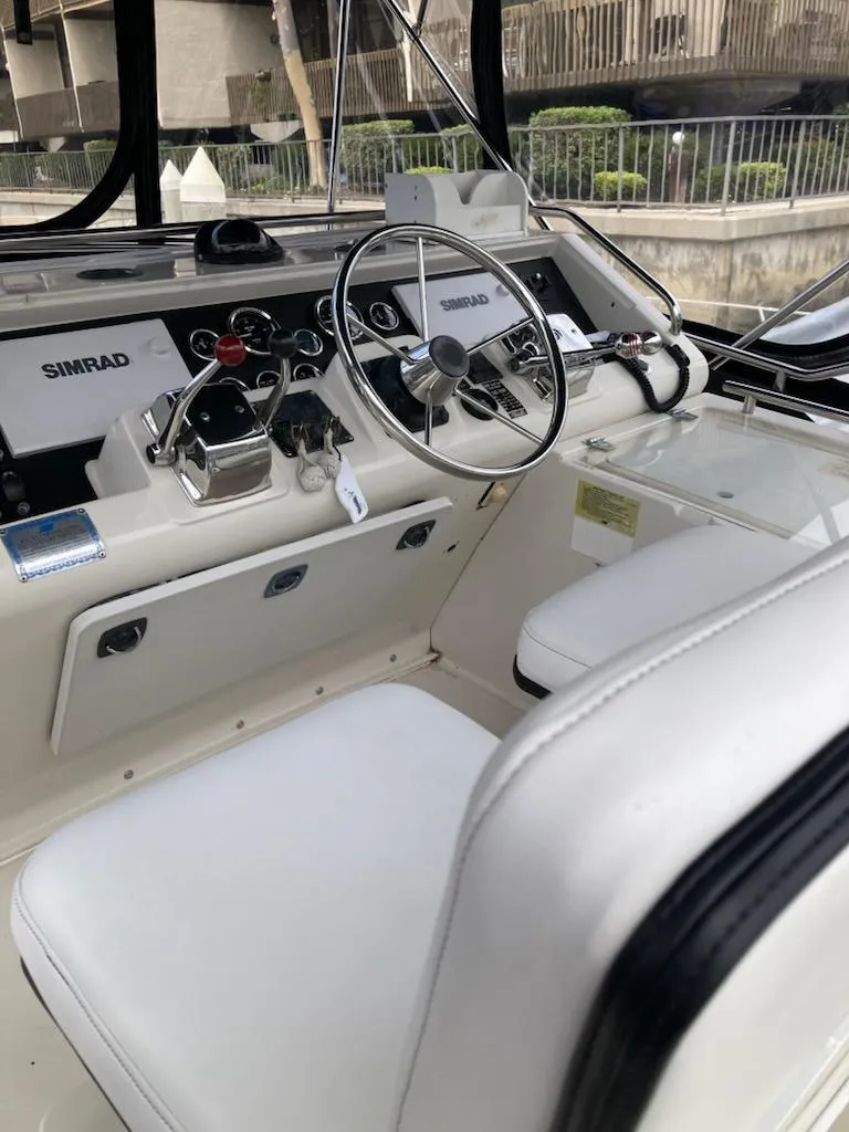 Slide: The Image of 1991 Wellcraft 3300 Sport Bridge helm with steering wheel and Simrad electronics. - 18