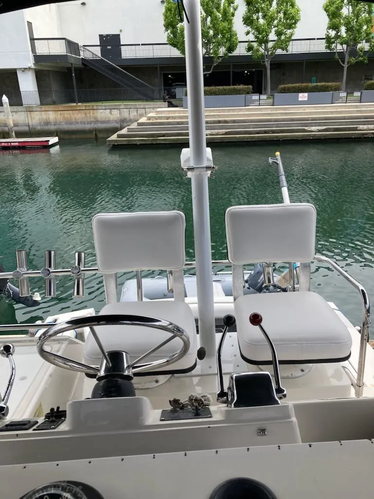 Slide: The Image of 1991 Wellcraft 3300 Sport Bridge helm with dual seats, docked by a calm waterfront. - 19