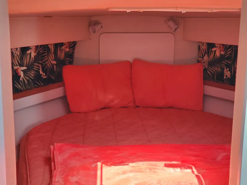 Slide: The Image of Cozy cabin interior of 1991 Wellcraft 3300 Sport Bridge with vibrant red bedding. - 2