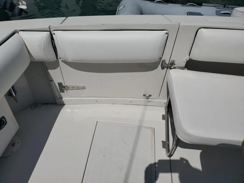 Slide: The Image of 1991 Wellcraft 3300 Sport Bridge boat interior with white seating and storage compartments. - 23