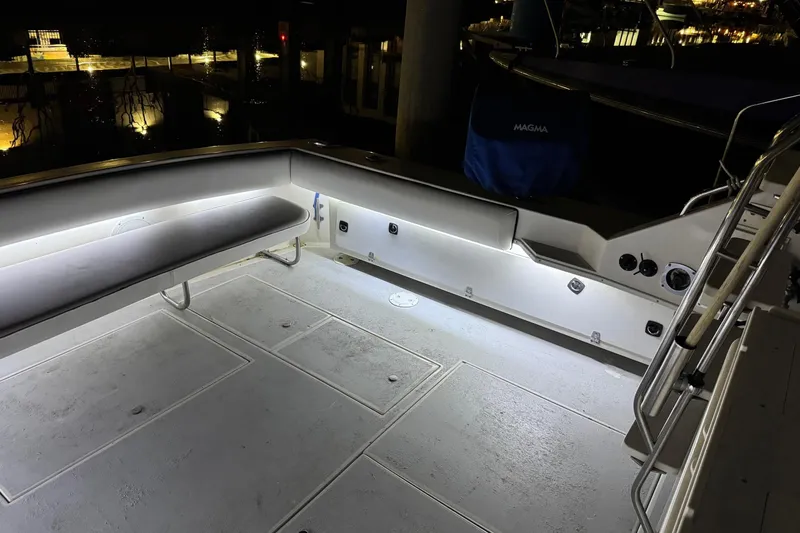 Slide: The Image of 1991 Wellcraft boat deck illuminated at night, featuring seating and storage compartments. - 26