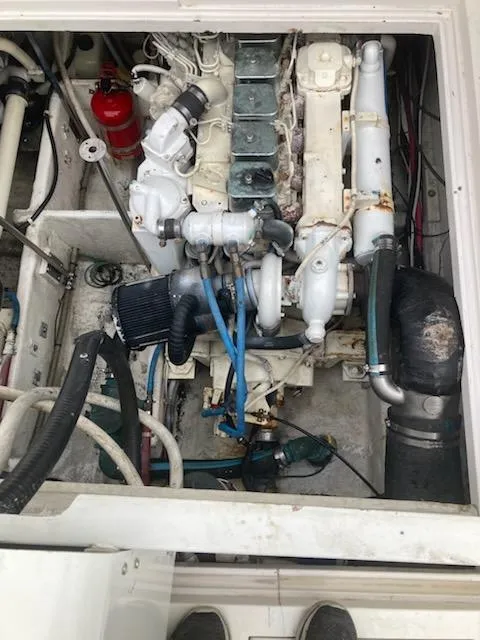 Slide: The Image of Engine compartment of a 1991 Wellcraft 3300 Sport Bridge, showcasing mechanical components and hoses. - 35