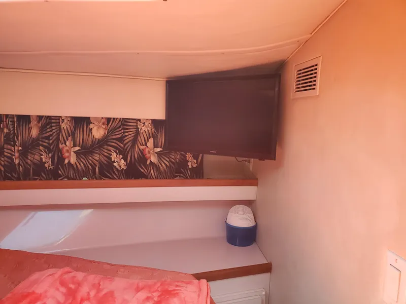 Slide: The Image of Interior cabin of 1991 Wellcraft 3300 Sport Bridge with floral wallpaper and TV. - 4