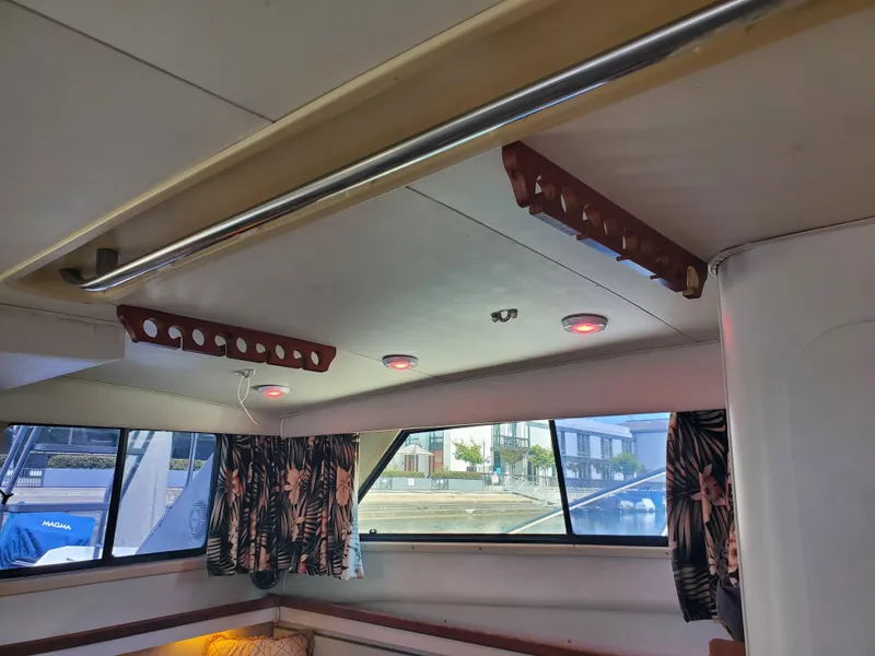 Slide: The Image of Interior of a 1991 Wellcraft 3300 Sport Bridge boat with windows and floral curtains. - 5