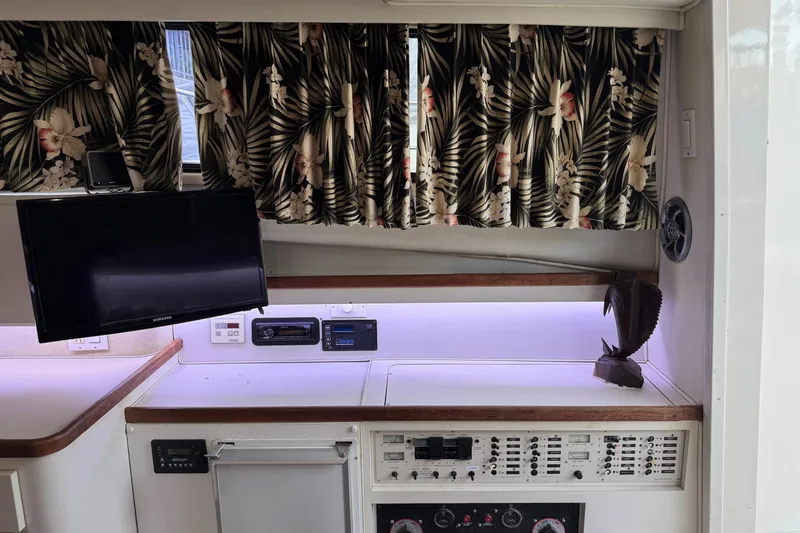 Slide: The Image of 1991 Wellcraft boat interior with floral curtains, TV, and control panel. - 6