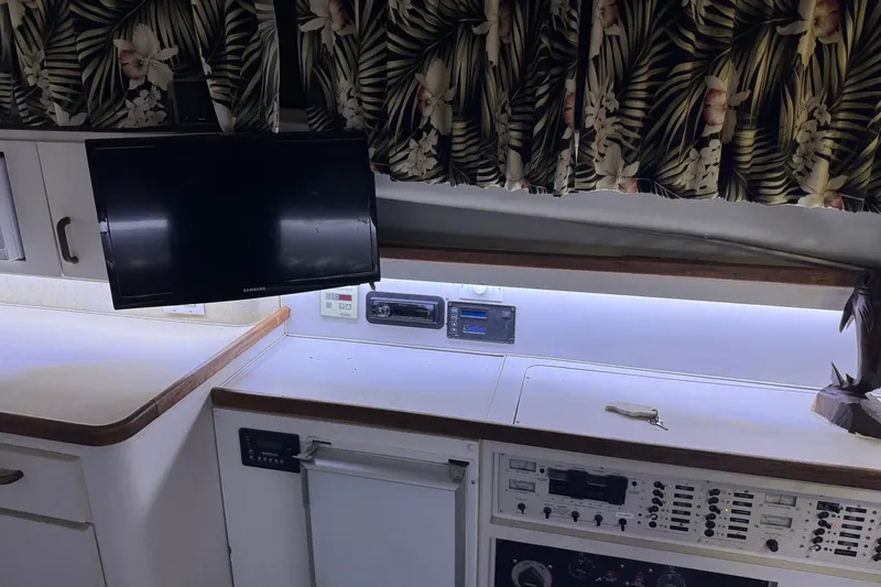 Slide: The Image of 1991 Wellcraft interior with TV, control panel, and tropical curtains. - 7