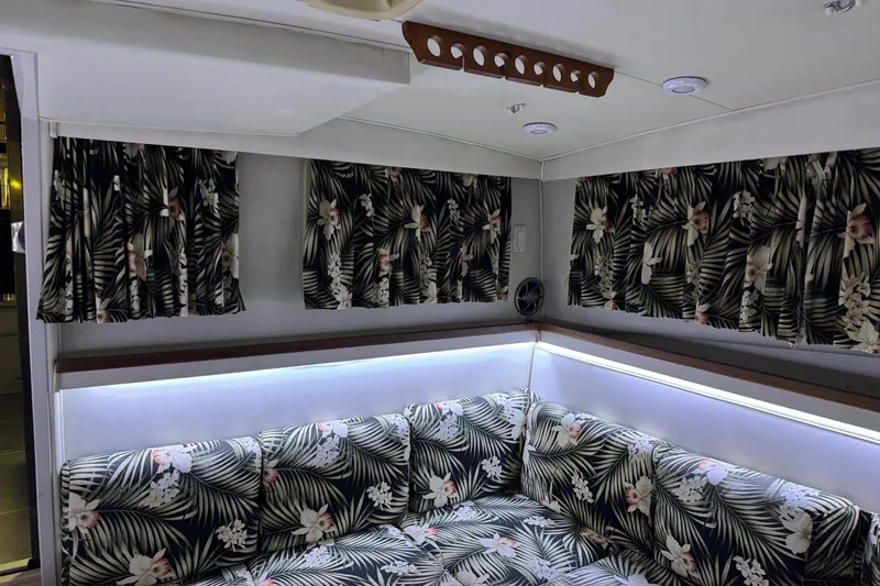 Slide: The Image of 1991 Wellcraft interior with tropical-patterned upholstery and curtains, featuring ambient lighting. - 9
