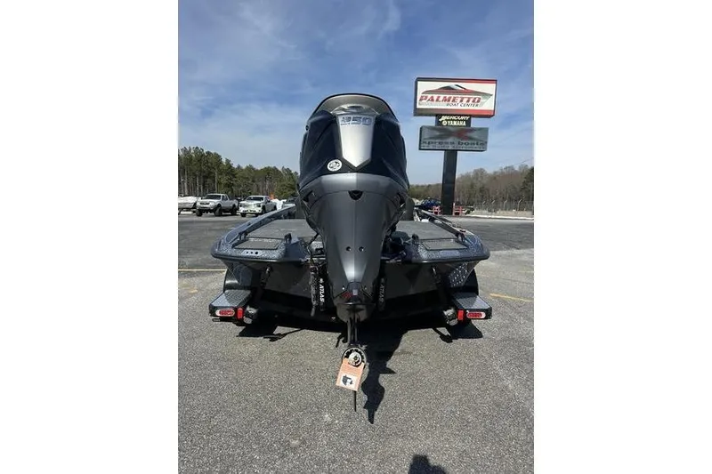 Slide: The Image of 2026 Phoenix 921 Elite X boat with powerful engine, parked outdoors under clear sky. - 2