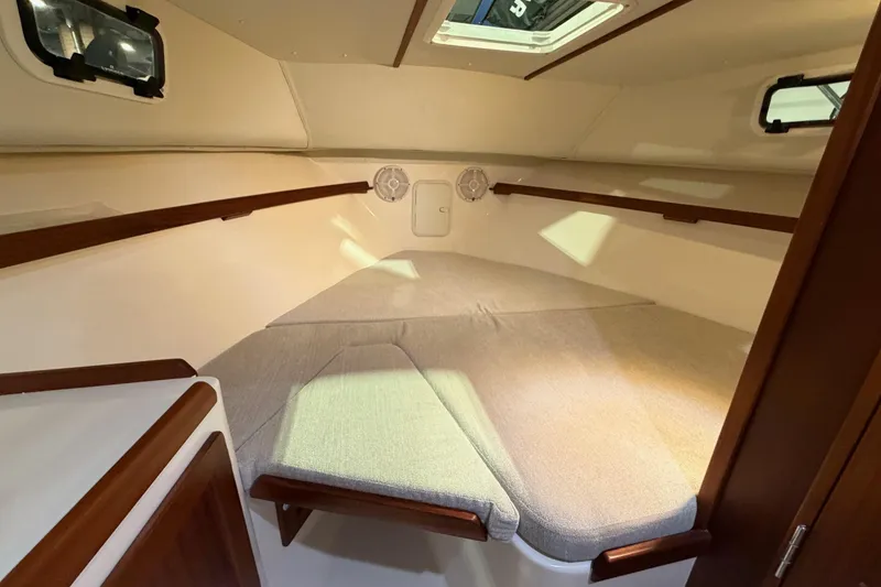 Slide: The Image of 2026 NorthCoast 255 Cabin interior with cozy sleeping area and wooden accents. - 10