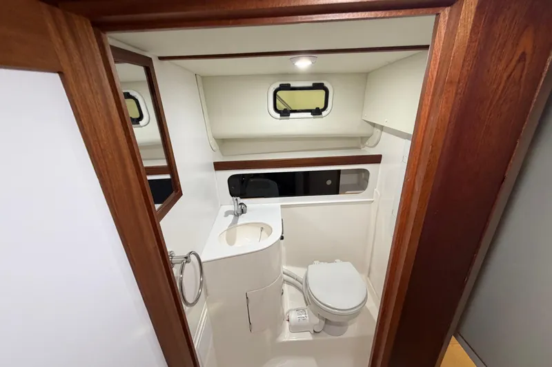 Slide: The Image of Compact bathroom in 2026 NorthCoast 255 Cabin boat with sink, toilet, and window. - 11