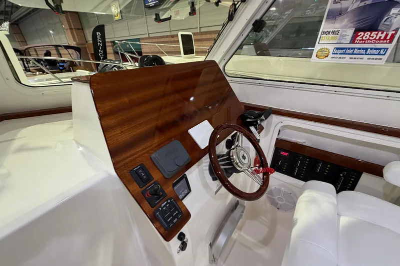 Slide: The Image of Interior view of 2026 NorthCoast 255 Cabin boat with wooden dashboard and steering wheel. - 6