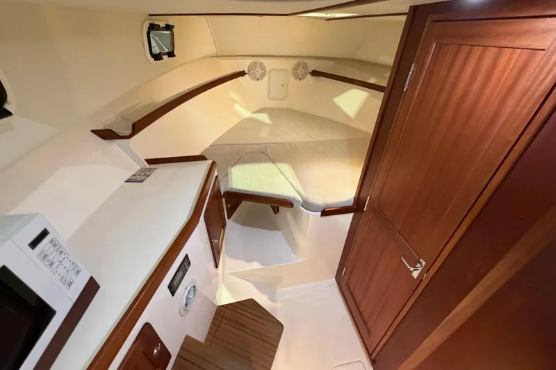 Slide: The Image of 2026 NorthCoast 255 Cabin interior with cozy bed and wooden cabinetry. - 9