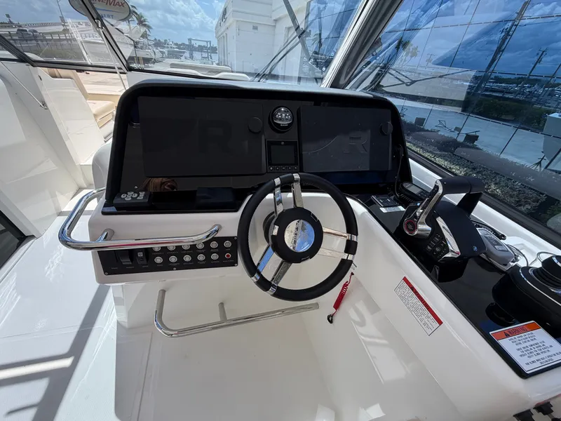 Slide: The Image of The cockpit of the 2026 Aquila 36 Sport features a modern steering wheel and instruments. - 22