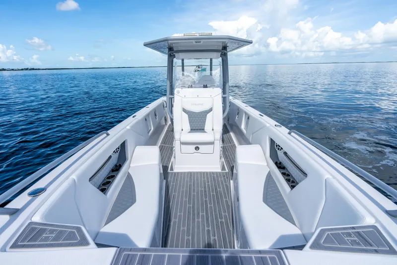Slide: The Image of 2023 Dynamic D-305V boat interior on calm ocean waters, showcasing sleek design and seating. - 8
